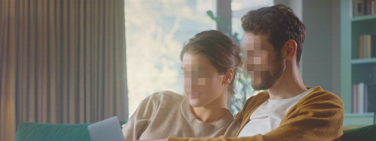 couple sitting on couch with pixelated faces